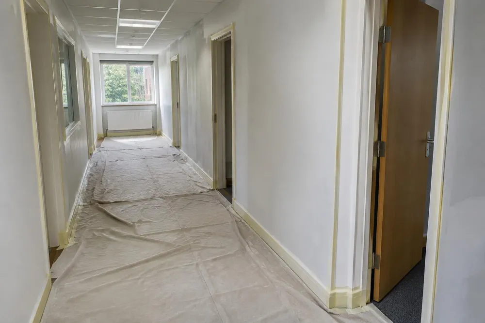 Office corridor with dust sheets and masking around door frames