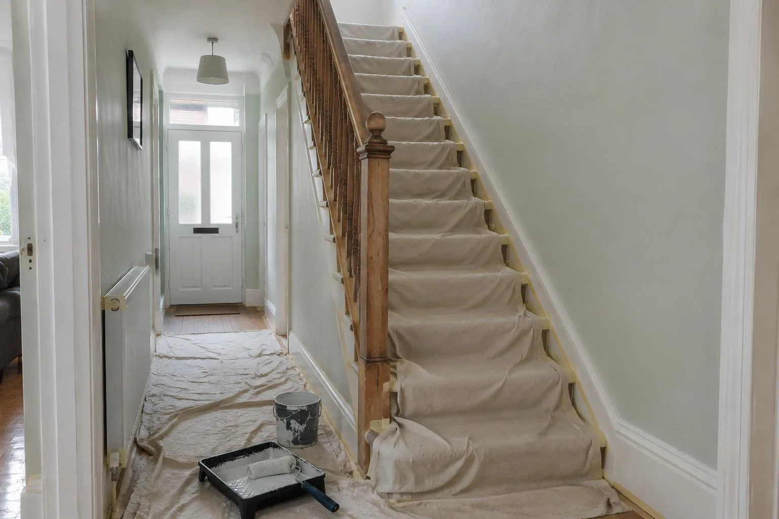 Home hallway and staircase protected with dust sheets during painting