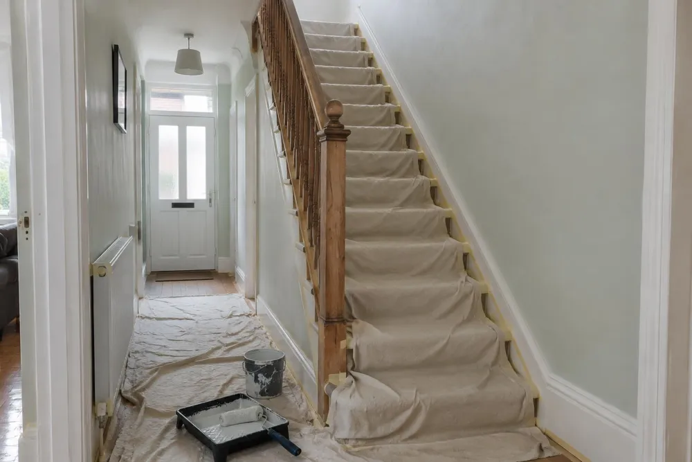 Home hallway and staircase protected with dust sheets during painting