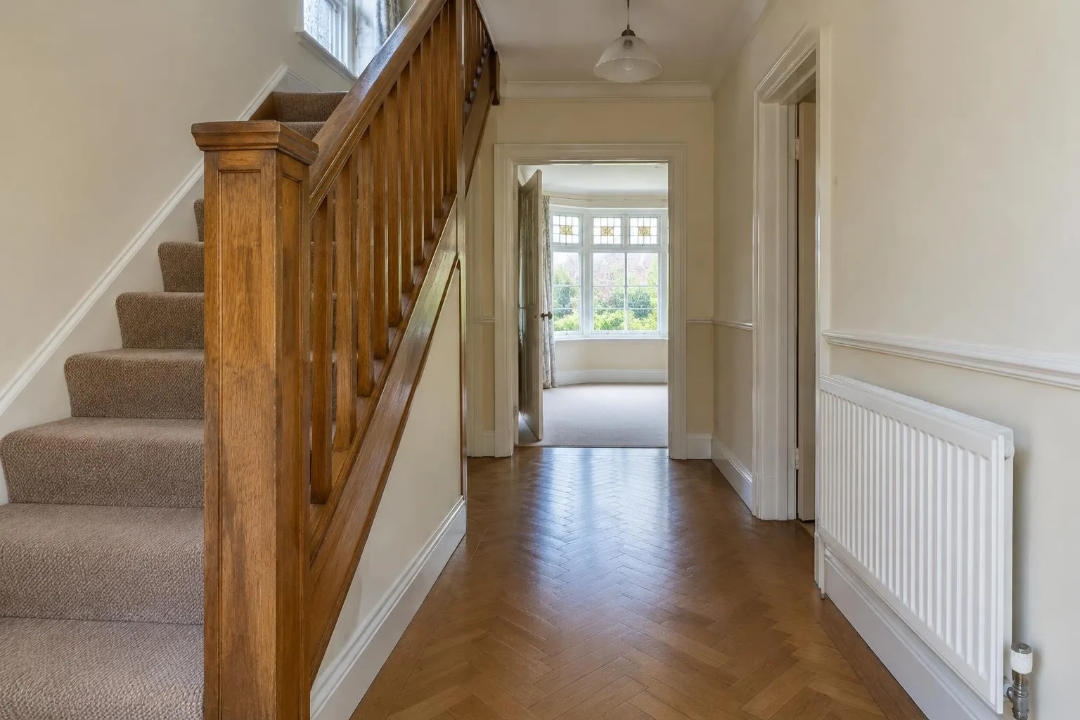 Suburban home hallway with timber staircase and painted skirting
